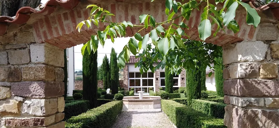 Jardin à la française vu à travers une arche en pierre